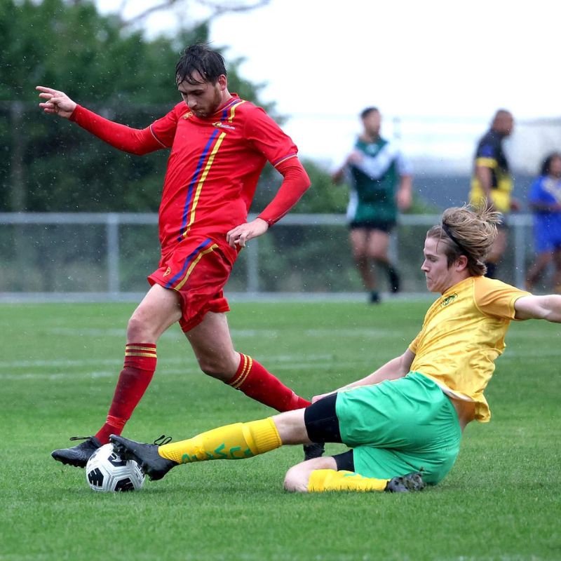 Lewis (in red) in action for Tawa AFC